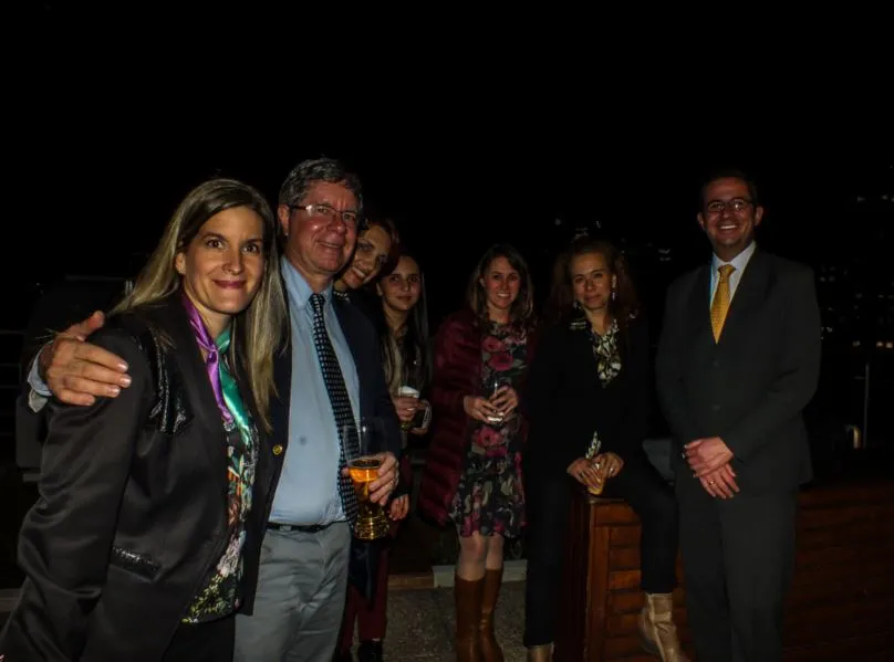Grupo de asistentes posa junto en una terraza de noche durante el foro de negocios verdes