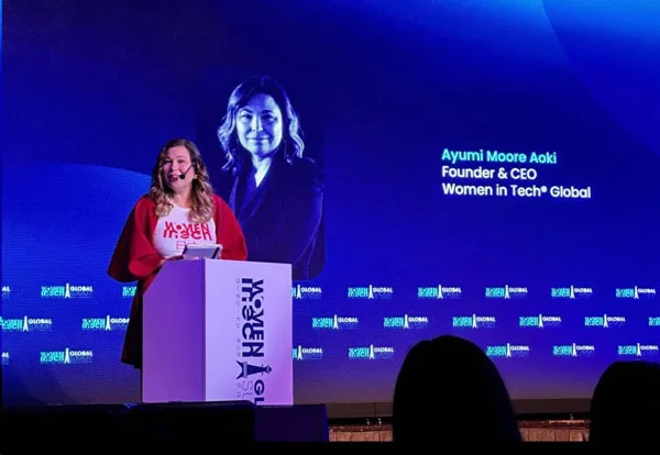 Ayumi Moore Aoki, fundadora y CEO de Women in Tech Global, habla en el podio del escenario de la cumbre