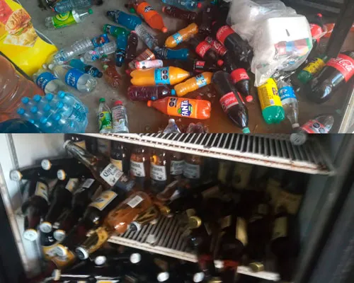 Botellas de refresco y agua caídas en una nevera y en el suelo tras el sismo