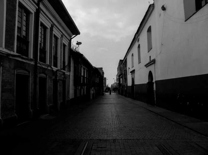 Calle empedrada vacía entre casas coloniales del centro de Bogotá durante la cuarentena