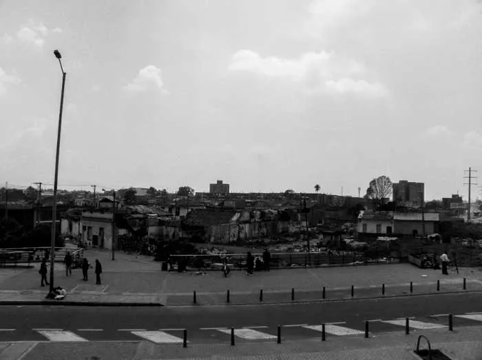 Calle vacía del barrio Santa Fe en Bogotá, en blanco y negro, con casas bajas al fondo