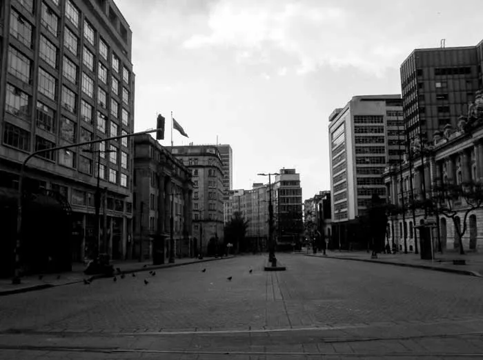 Calle vacía entre edificios altos del centro de Bogotá durante la cuarentena, en blanco y negro