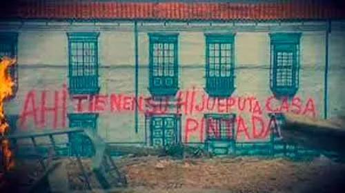 Fachada de una casa colonial con la frase pintada en rojo «Ahí tiene su hijueputa casa pintada»