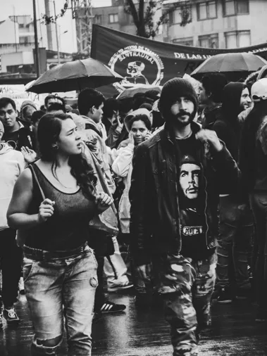Estudiantes marchan bajo la lluvia, un joven con camiseta del Che Guevara, en la concentración del 10 de octubre en Bogotá