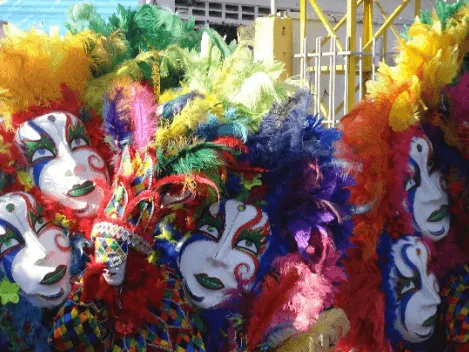 Grupo de disfraces de carnaval con máscaras blancas y plumas de colores vivos