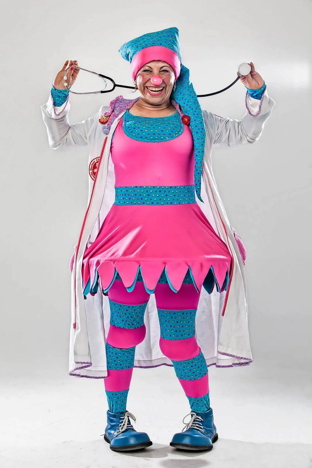 Payasa con traje rosa y azul, gorro azul y medias de rayas, de la Fundación Doctora Clown