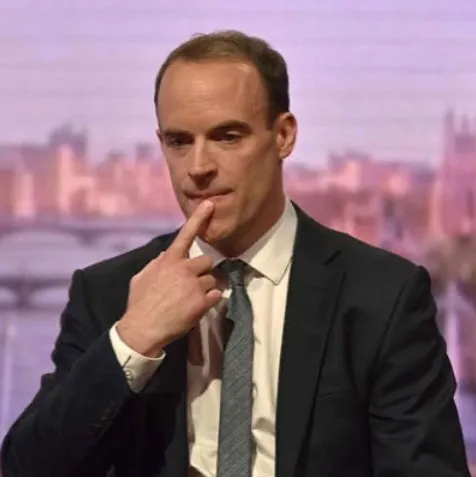 Dominic Raab, secretario de Justicia británico, con traje oscuro y un dedo sobre los labios durante una entrevista
