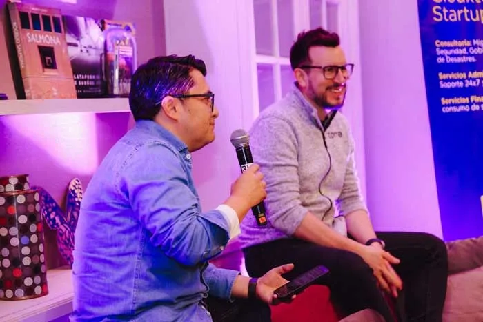 Dos hombres conversan con micrófono ante el público en el evento de Clouxter