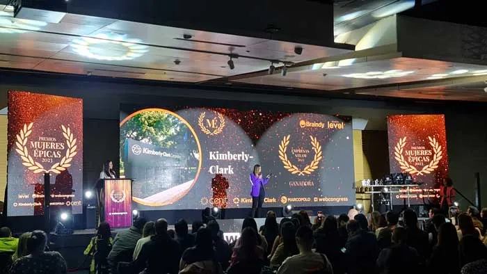 Salón de la gala Mujeres Épicas 2023 con público frente a un escenario y pantallas con imágenes de las homenajeadas