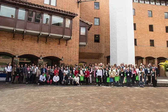 Asistentes al Foro Negocios Conscientes posan en grupo en un patio de ladrillo