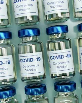 Filas de frascos de vacuna «COVID-19 Coronavirus Vaccine» con tapa azul