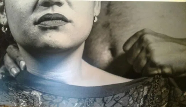 Primer plano en blanco y negro del cuello y la boca de una mujer con una mano masculina sobre su hombro, sobre acoso sexual