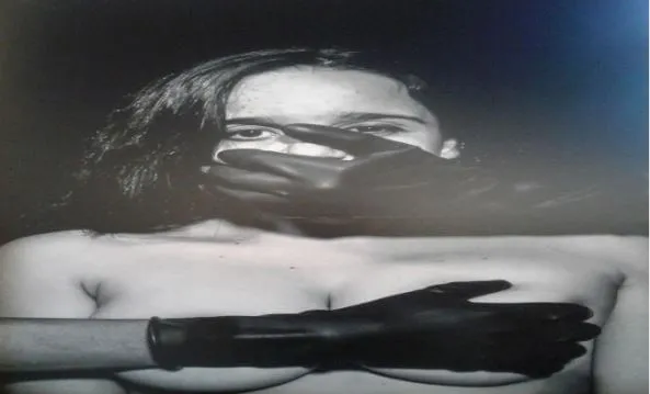 Retrato en blanco y negro de una mujer con la boca cubierta por una mano enguantada, de la serie «Más que cifras…son personas»