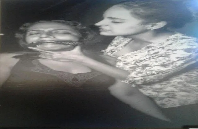Dos mujeres, una de ellas con la boca cubierta y sujetada por la otra, en la serie «Ni golpes que hieren, ni palabras que duelan»