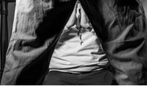 Persona de pie con las piernas abiertas y una camiseta blanca vista desde abajo, de la serie «Secretos por contar»
