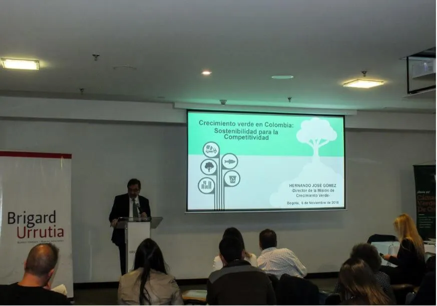 Hernando José Gómez expone en un atril ante una pantalla sobre crecimiento verde en Colombia