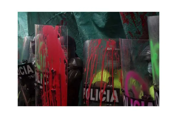 Escudos antidisturbios de la policía manchados con pintura roja, verde y morada durante el 8 de marzo