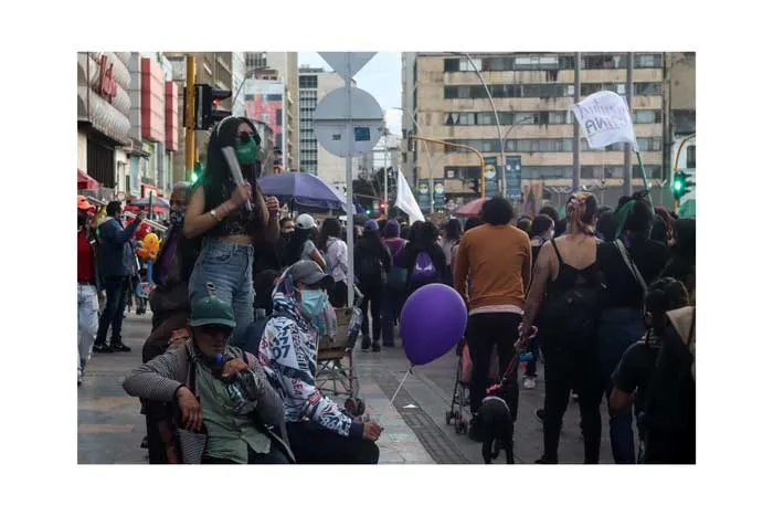 Multitud en una calle del centro de Bogotá con globos morados y pancartas durante la huelga del 8 de marzo