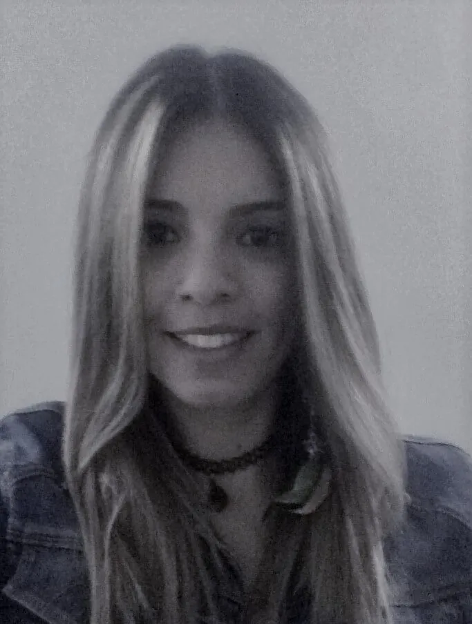 Retrato de Jenny García González, sonriente, de cabello largo y chaqueta de mezclilla