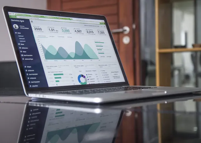 Laptop abierta con un panel de estadísticas y gráficos sobre un escritorio