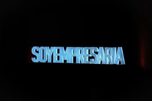 Letrero luminoso azul con la palabra «SOYEMPRESARIA» sobre fondo negro