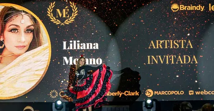 Bailarina con vestido rojo y negro en el escenario ante la pantalla «Liliana Moreno, Artista invitada»