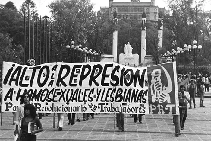 Marcha en blanco y negro tras una pancarta «¡Alto a la represión a homosexuales y lesbianas!» del Partido Revolucionario de los Trabajadores