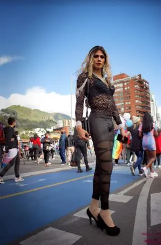 Persona con atuendo negro transparente y tacones camina por la calle durante la Marcha del Orgullo en Bogotá