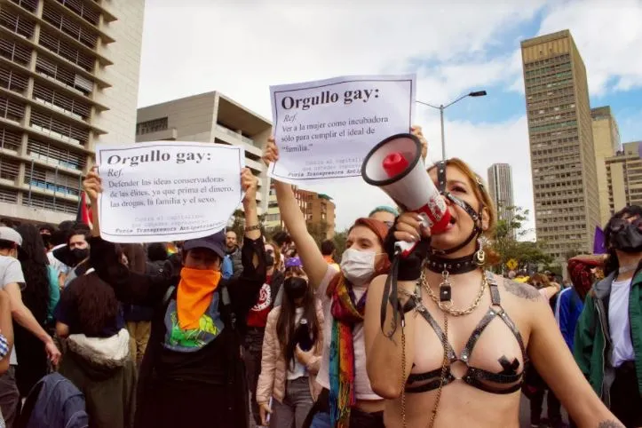Persona con un megáfono grita ante carteles «Orgullo gay» durante la Marcha del Orgullo