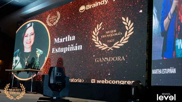 Pantalla del escenario que anuncia a Martha Estupiñán como ganadora de Mujer Tecnología 2022 en Mujeres Épicas de Revista Level