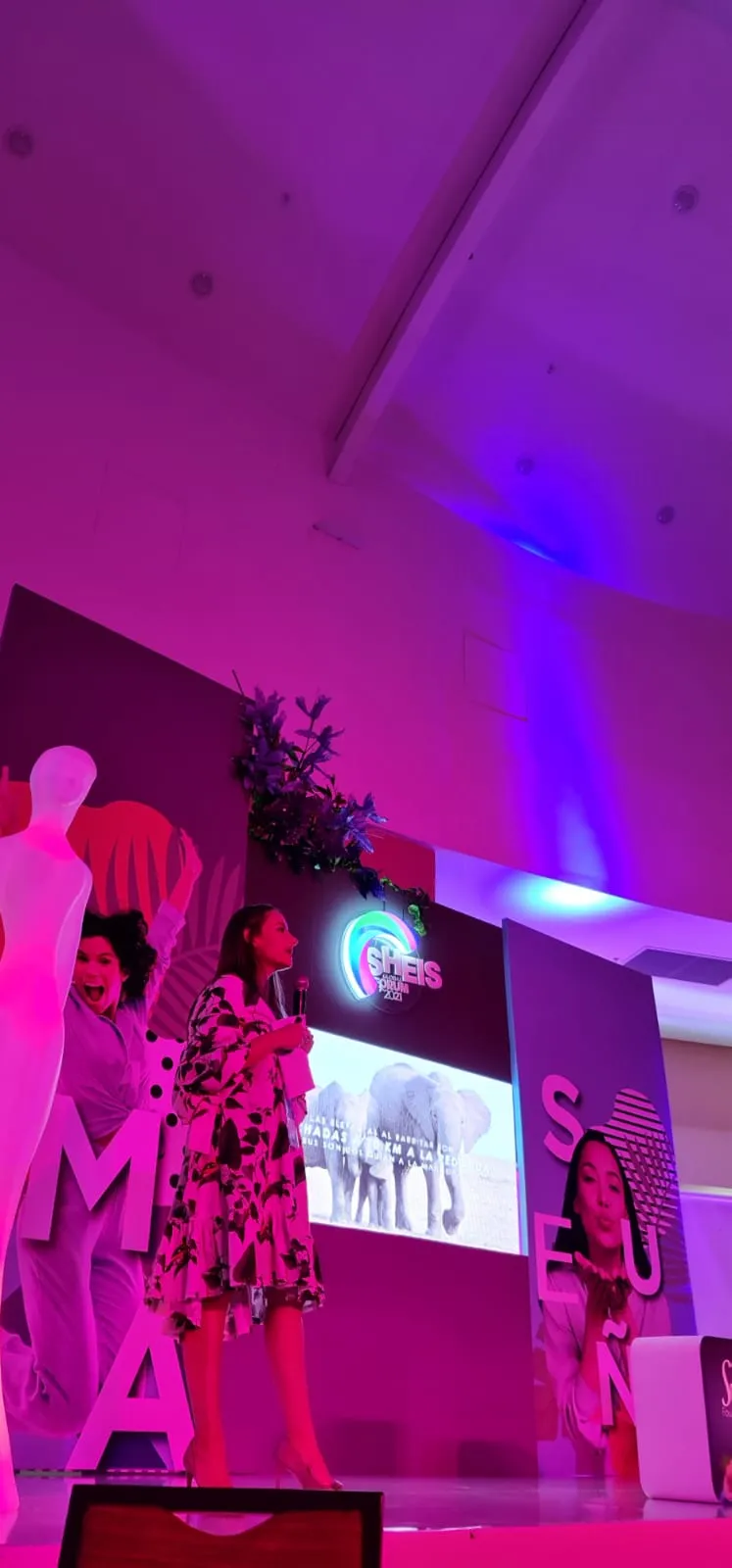 Mujeres sobre el escenario del foro con luces moradas y rosadas