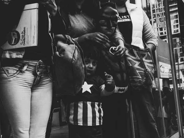 Multitud de personas apretadas en una protesta, con un niño en primer plano, en blanco y negro