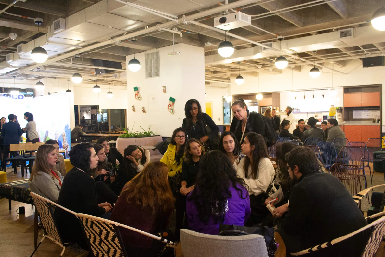 Asistentes conversan en mesas y sillones durante el networking de alianzas para la movilización social