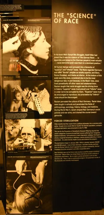 Panel de museo «The "Science" of Race» con fotografías y texto explicativo sobre fondo oscuro