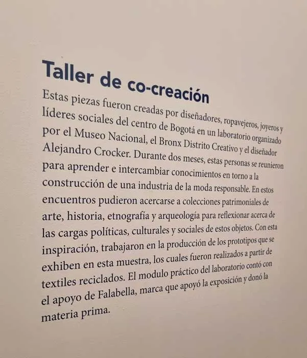 Panel de texto de la exposición titulado «Taller de co-creación» sobre piezas hechas con textiles reciclados