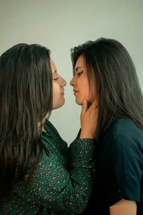 Dos mujeres de cabello largo se miran de frente muy cerca una de la otra