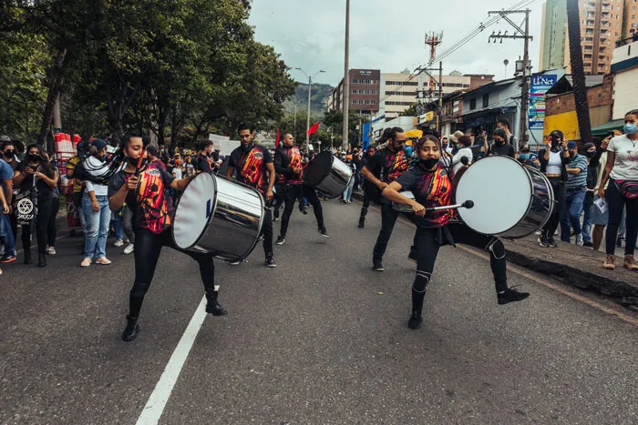 Grupo de percusionistas con tambores marcha por una calle durante el paro nacional