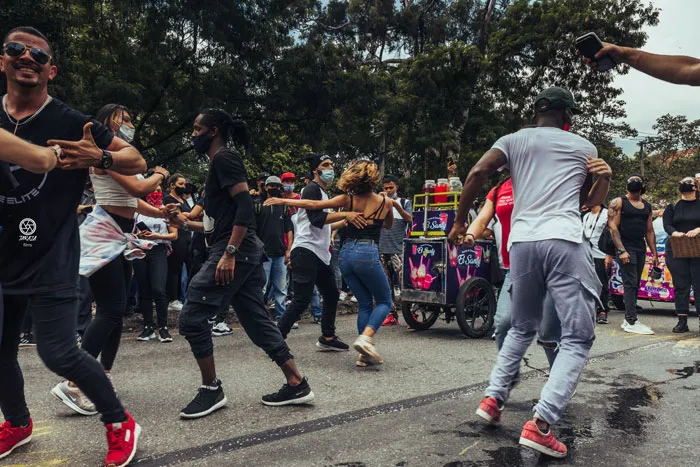 Grupo de personas baila en plena calle durante una marcha