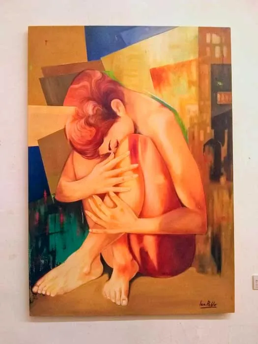 Pintura de una mujer de cabello rojo sentada y abrazada a sus rodillas, en tonos cálidos
