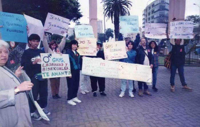 Grupo de personas con carteles en un plantón de la marcha del Orgullo, con mensajes como «Gays, lesbianas y bisexuales te amamos»