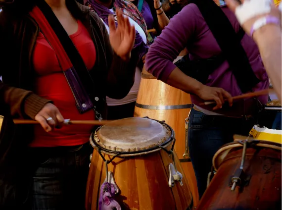 Primer plano de mujeres tocando tambores durante una marcha