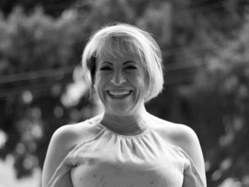 Retrato en blanco y negro de una mujer mayor de cabello corto sonriendo