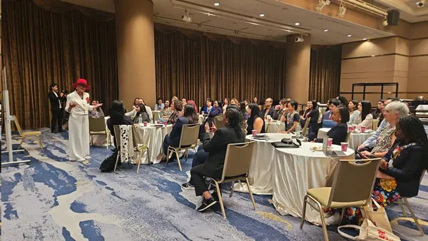 Salón de banquetes con mesas redondas llenas de asistentes durante la Cumbre Global de Mujeres en Tecnología en Osaka
