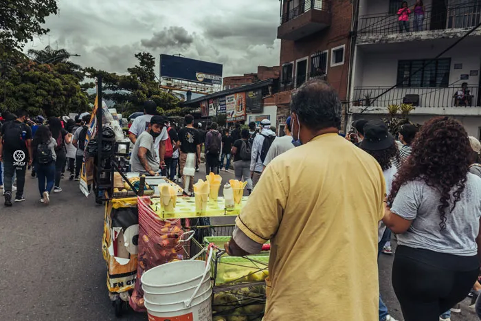 Vendedor con un carrito de comida entre la multitud de una marcha
