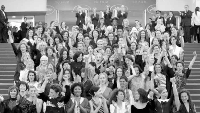 Cientos de mujeres levantan los brazos en las escaleras de un gran evento